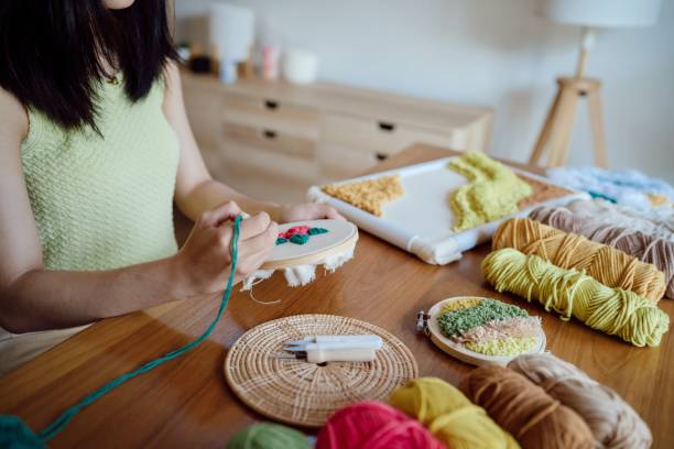istock Punch needle. Asian Woman making handmade Hobby knitting in studio workshop. designer workplace Handmade craft project DIY embroidery concept. 1486743790