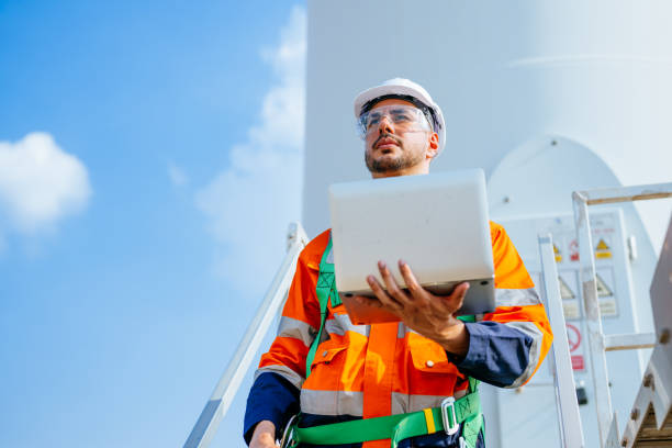istock Professional engineer using walkie-talkie working at wind turbine farm 1486746137
