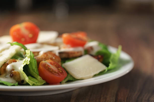 istock caesar salad with cherry tomatoes on wooden table 1486746196