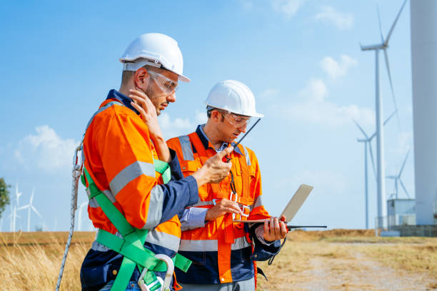 istock Professional engineers technicians working at wind turbine farm field 1486747192