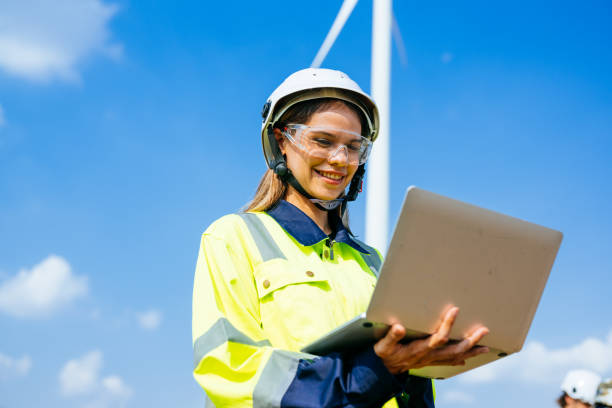 istock Happy female engineer technician working outdoor at wind turbine field 1486748824