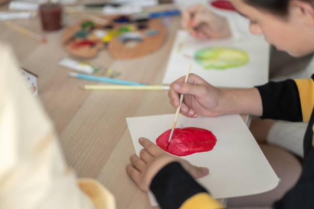 istock Kid attend and join to the arts class and using paintbrush drawing and painting artwork. 1486749583