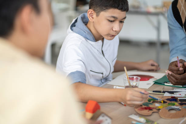 istock Boy enjoy drawing and painting in arts class. kid using paintbrush sketch on paper. practicing art skill, teacher support creative thinking idea. school activity, learning and education concept 1486749586