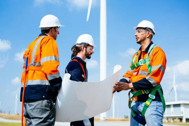 istock Professional engineers technicians working at wind turbine farm field 1486749640