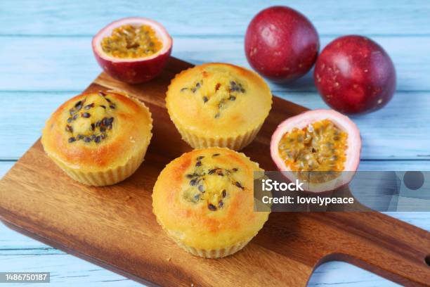 Delectable Passion Fruit Muffins On A Wooden Breadboard With Fresh Fruits Scattered Around Stock Photo - Download Image Now