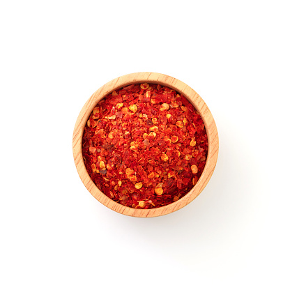 Chili powder in wooden bowl isolated on white background , top view , flat lay.