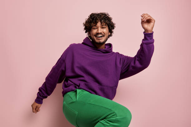 istock Playful young Indian man dancing and smiling against pink background 1486758375