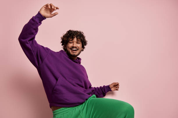 istock Excited young Indian man dancing and smiling against pink background 1486758383
