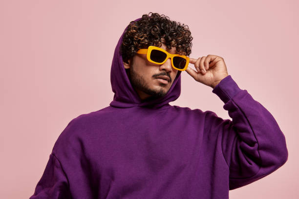 istock Handsome young Indian man adjusting his sunglasses against pink background 1486758492
