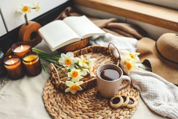 istock Spring still life, cup of tea, candles, open book and hat 1486760251