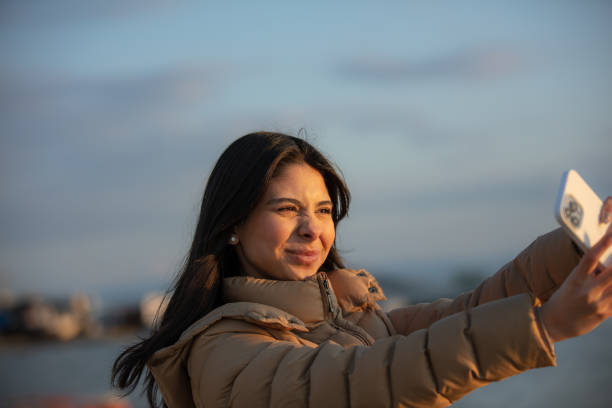 istock Black haired young woman is taking a selfie on the outside. 1486762604