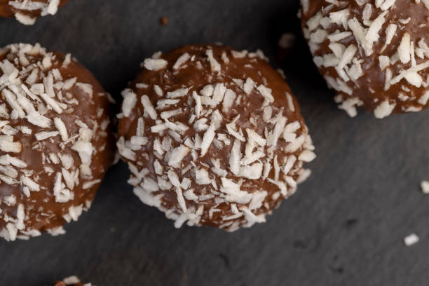 Chocolate candies with milk coconut filling and coconut chips, delicious and soft chocolate coconut cakes for dessert