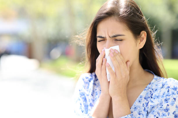 istock Ill woman blowing or coughing on tissue 1486769571