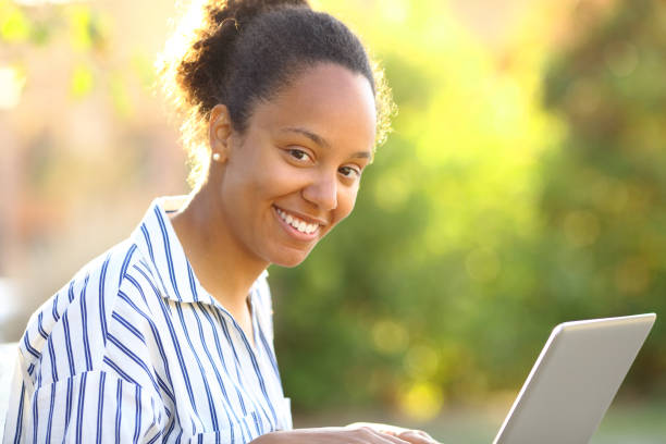 istock Happy black woman using laptop looking at you 1486769627