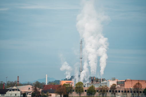 Industrial power plant in the countryside, releasing polluting emissions.