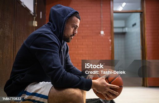 istock Male Basketball Star With Basketball In Locker Room 1486770832