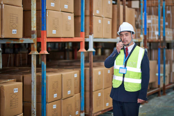 istock One Asian Man Examining Shelf and Talking on Walkie-talkie 1486773511