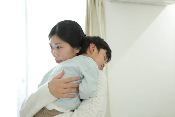 病気の男の子の世話をする母親 - 産後うつ ストレス 日本人 女性 ストックフォトと画像