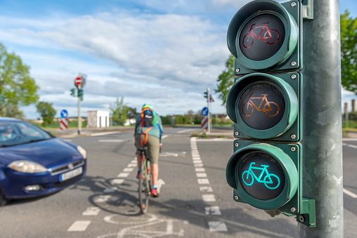 Near crash between a cyclist crossing a road at green phase and an approaching car