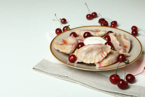 istock Plate with pierogi with cherry on kitchen towel on white background 1486780894