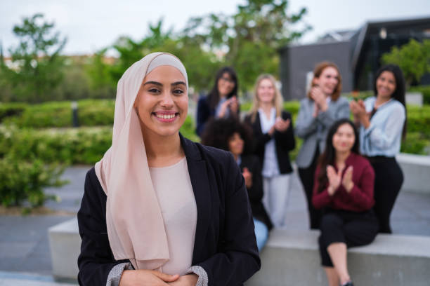 istock Young woman with hijab smiles applauded by her co-workers 1486780927