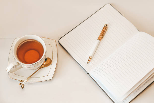 istock White cup and saucer with golden spoon and notepad 1486783171