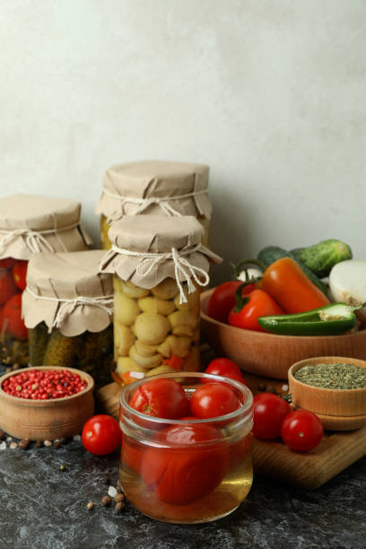 istock Jars of pickled vegetables and ingredients on black smokey table 1486784202