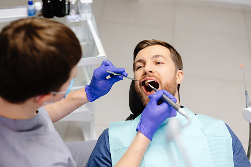 Man having teeth examined at dentists. Overview of dental caries prevention.