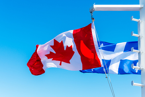 Canadian and Quebec provincial flag flying side by side