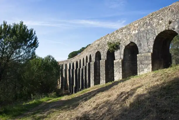 Photo of Wonderful landscapes in Portugal. Beautiful scenery of Aqueduct of the Convent of Christ in Tomar. It is 6 kilometres long with a total of 180 arches. Sunny spring day. Selective focus