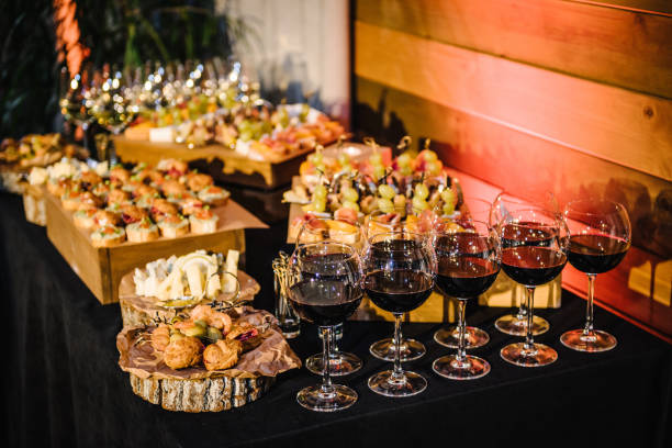 istock Buffet table. Mini cold snacks, canapes, and appetizers with alcohol for public catering on black table. Food on wooden plates, serving board on festive table, corporate food. Party and holiday away. 1486790946