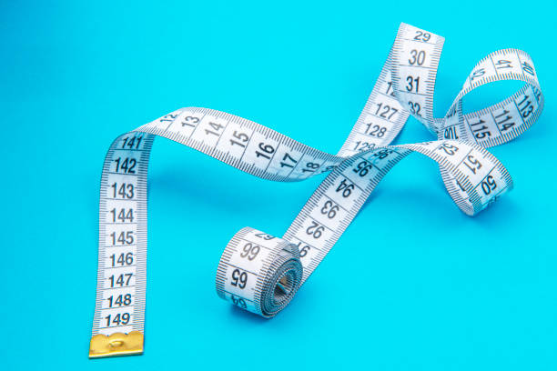 istock White measure tape on blue backgrond with copyspace 1486792917