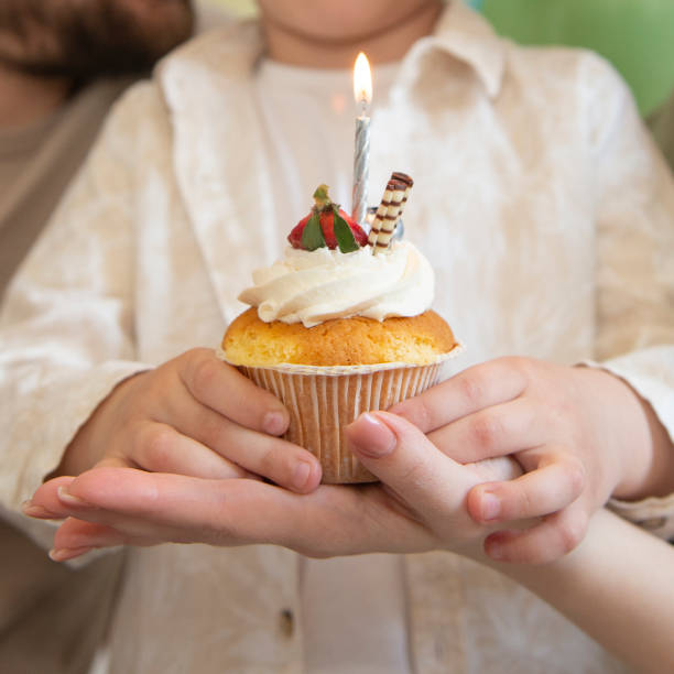 istock Birthday muffin with candle in hand selective focus 1486795216