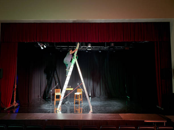 istock Young male light technician standing on a ladder installing spotlights 1486800132