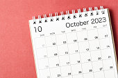 A October 2023 calendar desk for the organizer to plan and reminder isolated on red background.