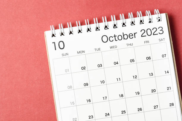 A October 2023 calendar desk for the organizer to plan and reminder isolated on red background. stock photo