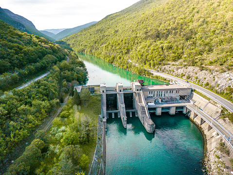 Aerial view of a small hydroelectric power plant located on the beautiful Soca river. Renewable energy is key to saving the environment. Sunset view.