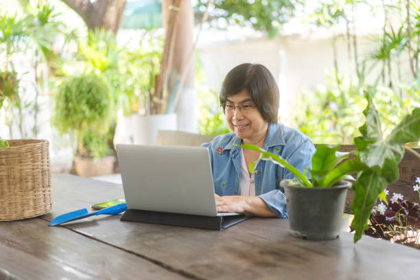istock Elder asian woman using laptop for working at home garden backyard 1486807562