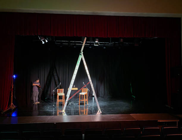 istock Young male light technician installing spotlights on a theater stage 1486809082