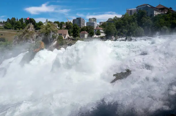 The roaring Rhine River cascading down Europe's largest waterfall, The Rhine Falls. The Rhine Falls runs between Zurich and Schaffhausen, Switzerland.