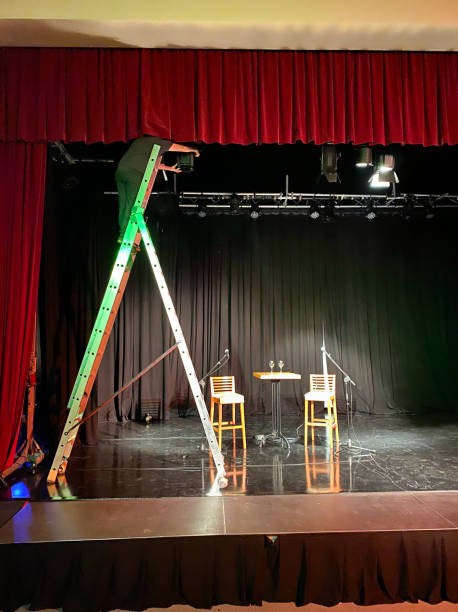 istock Young male light technician standing on a ladder installing spotlights 1486809734