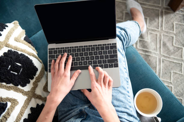 istock Woman using laptop and chill on sofa with tea 1486809972