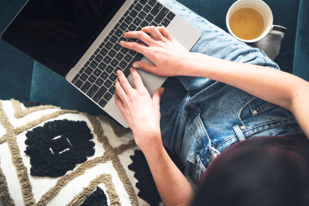 istock Woman using laptop and chill on sofa with tea 1486810008