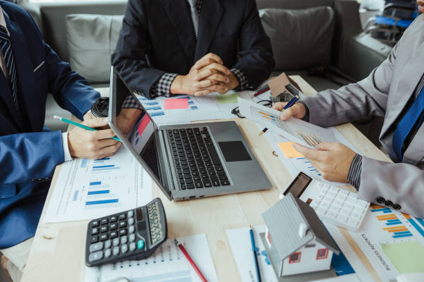 istock Teamwork with businessmen analyzing cost graphs on table at conference room. 1486813301