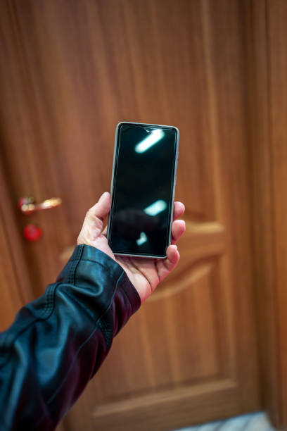 mobile phone is in man hand focus on foreground door is background vertical still