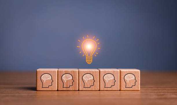 istock brainstorming creative idea and innovation. Hand putting over wooden cube block with light bulb icon on many people together having an idea symbolized by icons on cubes. 1486818924