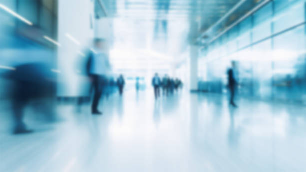 istock Business people walking in office, blurry working space with defocused effect, blurred motion business background 1486821175