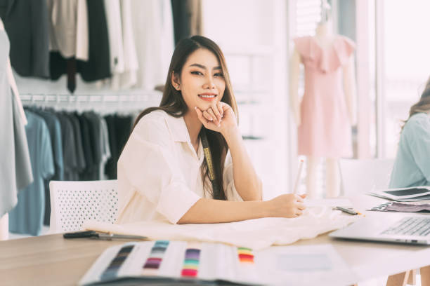 istock Asian woman designer busy making clothes work or study in fashion design studio 1486822036
