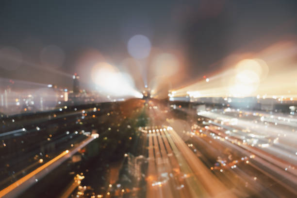 Blurred abstract background of skyscrapers at night with bokeh lights trail using zoom technique.