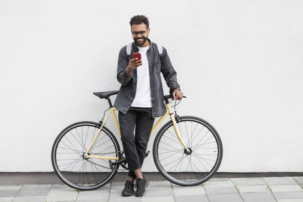 istock Happy man with bicycle using smart phone in a city 1486834257